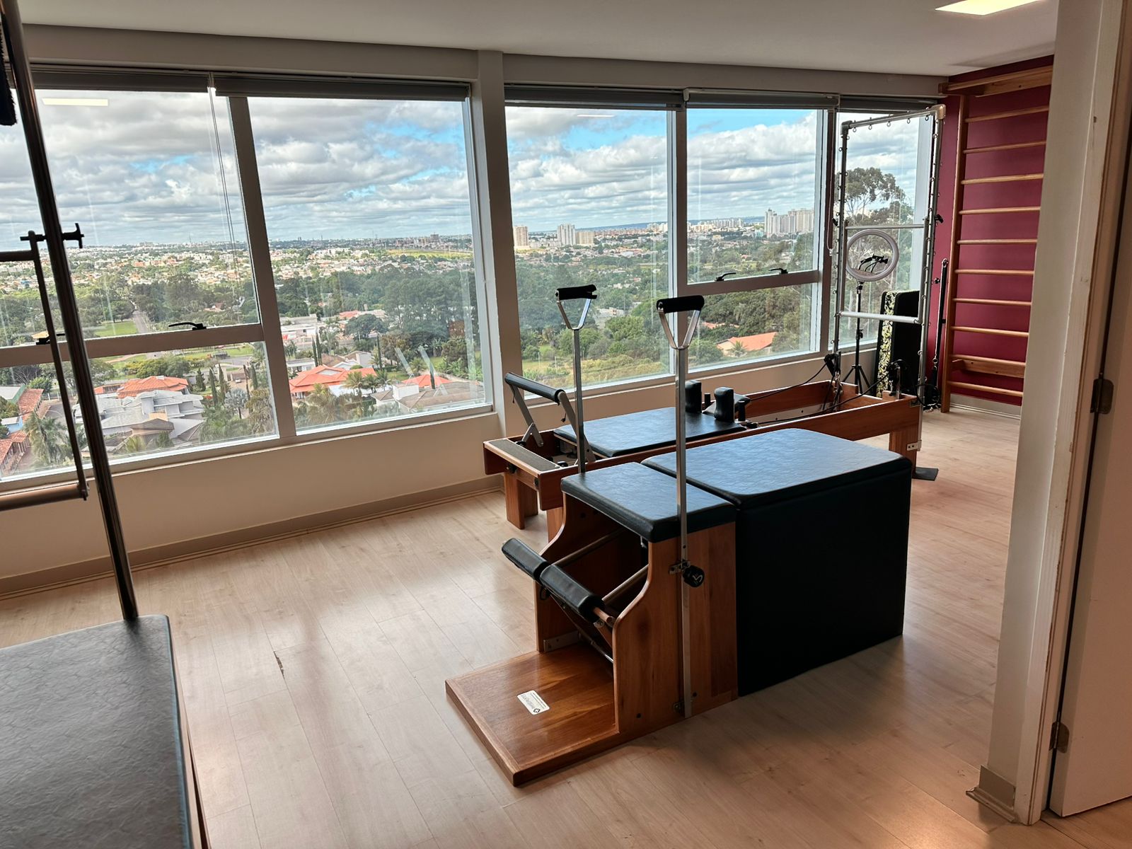 Sala de Pilates com equipamento reformer e vista espetacular da cidade