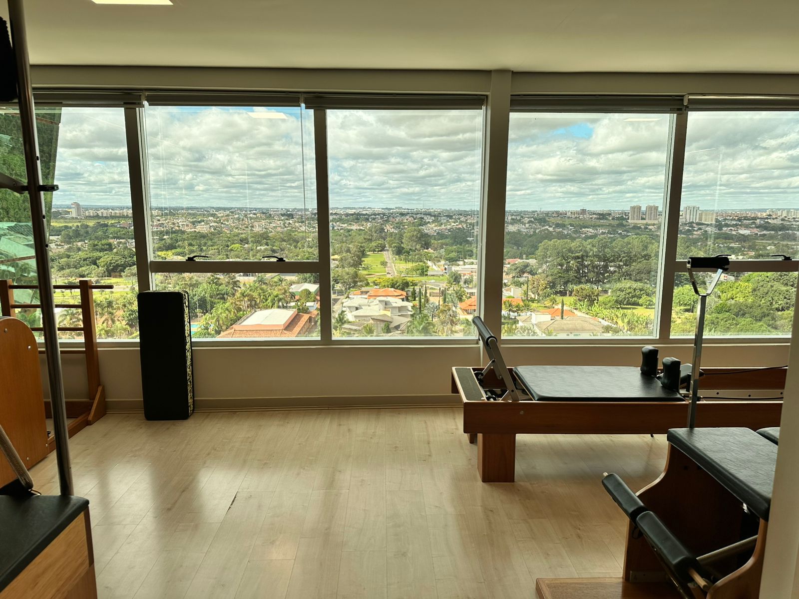 Estúdio de Pilates espaçoso com vista panorâmica e equipamentos profissionais